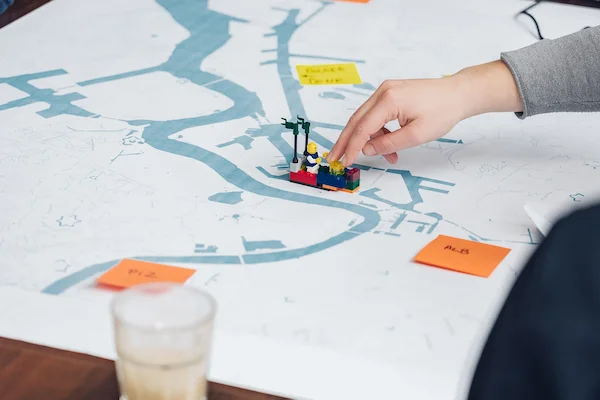 LEGO model of a ship on a map of the Port of Antwerp, surrounded by workshop post-its